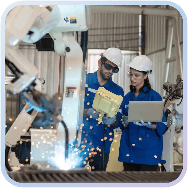 Automotive manufacturing factory workers in safety gear inspecting scanner data.